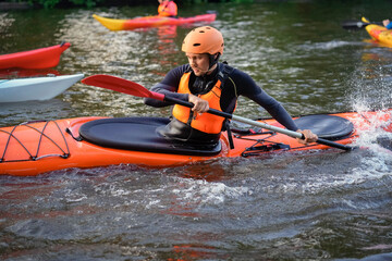 Participants paddle on a calm river at sunset, showcasing vibrant kayaks and a peaceful atmosphere. The water reflects the warm colors of dusk as outdoor enthusiasts engage in the sport