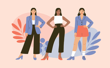 Obraz premium Three fashionable women in stylish outfits pose confidently against a soft pastel pink and coral backdrop showcasing modern elegance