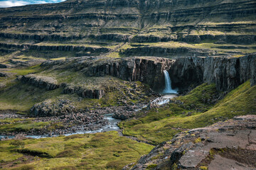 H&aelig;nubrekkufoss waterfall in terraced valley landscape, East Fjords, Iceland