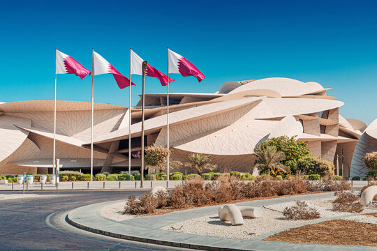 30 November 2025, Doha, Qatar: National Museum featuring unique desert rose inspired architecture, with Qatari flags