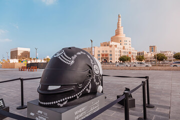 Fototapeta premium 30 November 2025, Doha, Qatar: Giant Formula 1 racing helmet sculpture featuring traditional arabesque designs, promoting the Qatar Grand Prix event