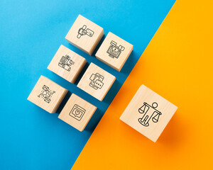Wooden blocks with digital technology icons on blue vs. a balance scale icon on orange, representing digital detox, work-life balance, and finding harmony in a tech-driven world.