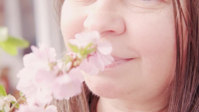 Female nose near pink cherry, sakura blossom, hay fever quiet discomfort, springtime and beauty nature, possibly reacting pollen, while also raising awareness seasonal allergies, Sensory Experience