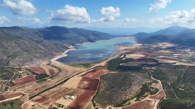 Aerial drone cinematic video of artificial lake of Yliki in Boeotia prefecture with calm waters and beautiful clouds, an important source of drinking water for the Athens, Greece
