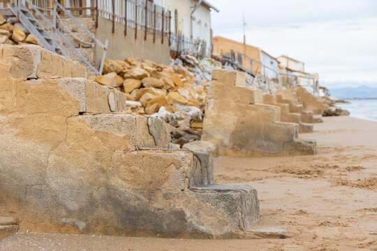A row of weather-beaten beach houses, the Casas de Babilonia, Babylon houses stands directly on the sandy shore of Playa de la Babilonia in Guardamar del Segura