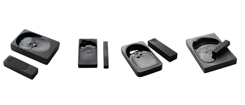A collection of traditional black inkstones and inksticks for calligraphy isolated on a white background.
