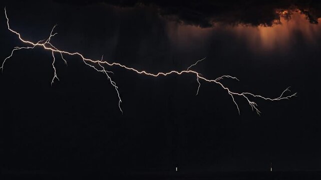 Lightning illuminates dark sky with dramatic flash during intense storm at dusk from a distant viewpoint