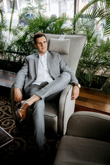 portrait of a young groom in a blue jacket and white shirt in a bright studio