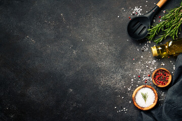 Spices and herbs at black top view.