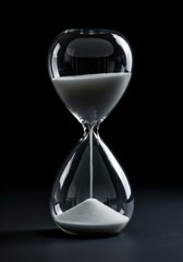 A traditional glass timer with white sand flowing steadily, isolated dramatically on a deep black background, symbolizing deadlines and duration, concept, falling, white sand