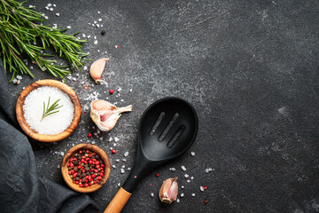 Spices and herbs at black top view.