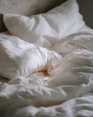 Close-up of messy silk bedding and pillows in Cloud Dancer white