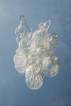 still life with antique glass vases on mirror reflecting the blue sky