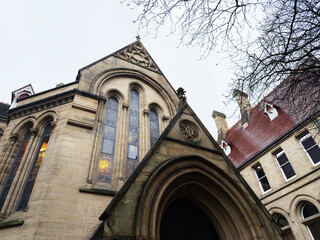 Naklejka premium Manchester church facade with arched stained glass windows and gothic architecture