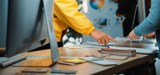 A vibrant workspace showcases professionals engaged in collaborative design activities. Colorful samples and materials are spread across a stylish table, highlighting creativity. SACTR