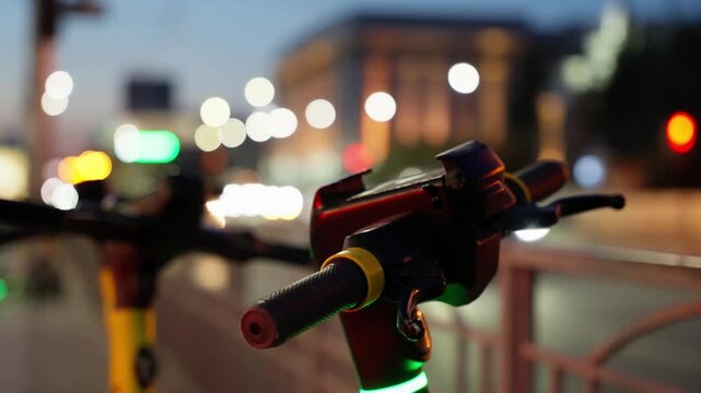 Close-up of electric scooter handlebars glowing at dusk with colorful bokeh city lights, urban street traffic, and railing in soft focus, capturing evening micro-mobility in motion.