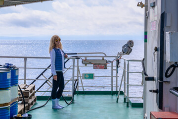 Woman enjoying a calm moment on a ship deck over the Russian waters