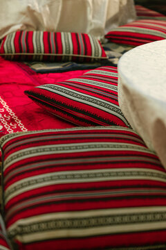 Red majlis cushions and striped traditional fabric close-up