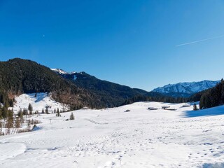 Snowy landscape around Spitzingsee in Bavarian Alps. Valley and Rote Valepp river at the bottom of slopes of the Schwarzenkopf and the wild forest reserve from the Rosskopf trail
