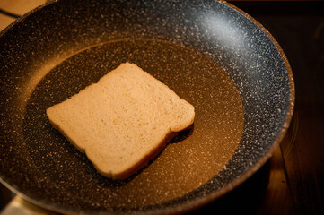 Slice of White Bread Sizzling in a Frying Pan for a Simple Breakfast