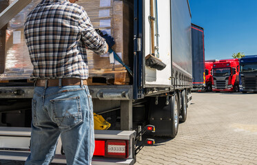 Worker Loads Boxes Onto a Truck at a Shipping Yard