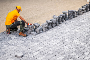 Worker Places Stones for Outdoor Construction