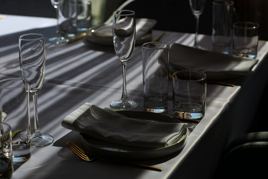 Beautiful table setting with dishes,in a restaurant,light-shadow pattern and style