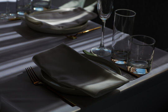 Beautiful table setting with dishes,in a restaurant,light-shadow pattern and style