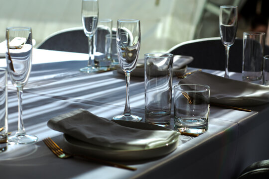 Beautiful table setting with dishes,in a restaurant,light-shadow pattern and style