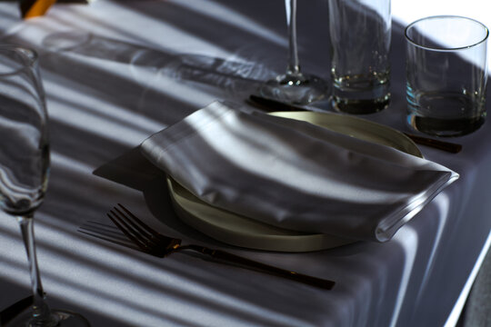Beautiful table setting with dishes,in a restaurant,light-shadow pattern and style