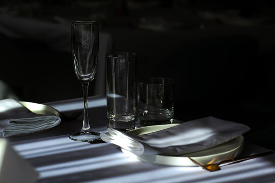 Beautiful table setting with dishes,in a restaurant,light-shadow pattern and style