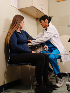 Nurse checks blood pressure of pregnant Native American woman