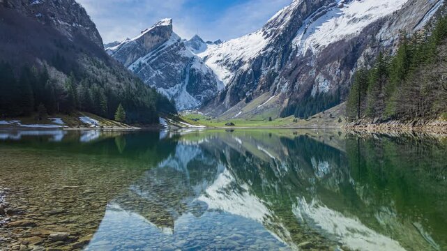 Time lapse, a scenic alpine lake surrounded by limestone cliffs and alpine pastures. Seealpsee view towards Saentis mountain peak, Appenzell Alps, Switzerland