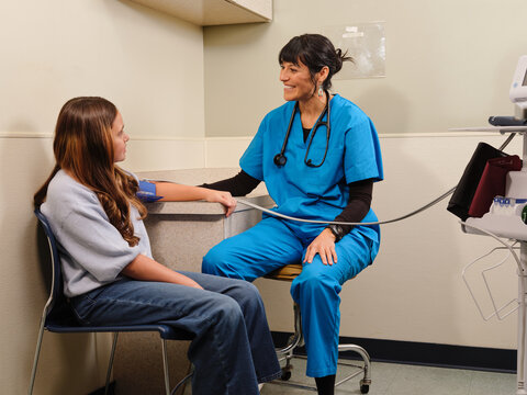 Native American nurse takes child's vitals at clinic