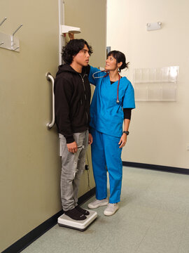 Native American healthcare worker takes teen boy's height