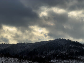 Mystical snowy Carpathian peaks under cloudy skies
