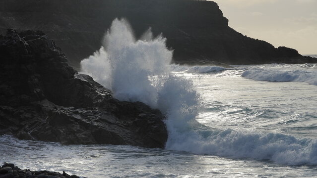 Spectacular sunset contemplating the force of the sea crashing agains the cliff