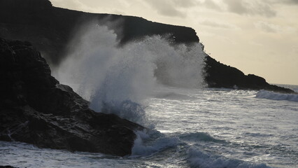 Obraz premium Spectacular sunset contemplating the force of the sea crashing agains the cliff