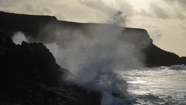 Spectacular sunset contemplating the force of the sea crashing agains the cliff