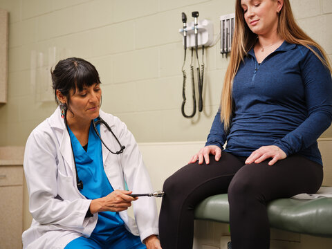 Native American woman has reflexes checked by nurse