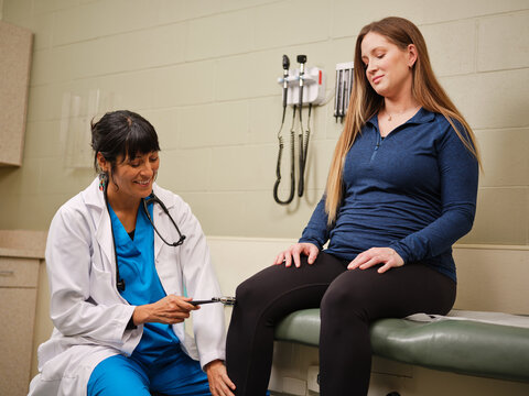 Indigenous nurse treats Native woman with reflex exam