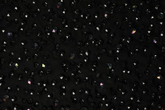 Texture of black fabric with rhinestones as background, top view