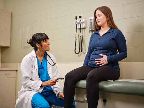 Indigenous nurse practitioner assessing knee reflexes