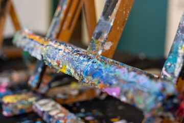 Paint-covered wooden easel detail. Abstract texture illustrating creativity, artistic process and contemporary visual art