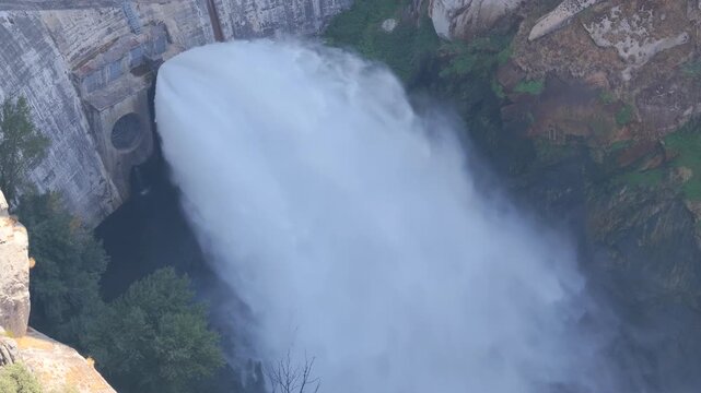 Aerial of dam with water jet, hydroelectric power plant, Presa de Almendra, Spain