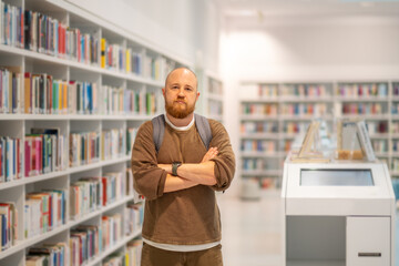 A bearded man  working and studying in a library