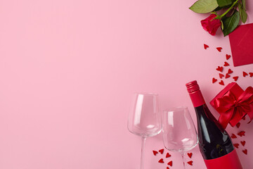 Valentine's day composition of red wine bottle, two glasses, gift box, envelope, rose and hearts