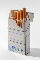 Open cigarette pack with yellow filter cigarettes sticking out, isolated on white with clipping path included
