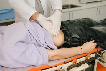 Male patient back examination with urologist palpating kidneys for pain.