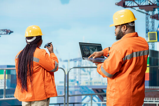 Exploration professional on drilling barge uses laptop to study geological maps for fossil fuel deposits. Offshore platform engineer performs site assessment uses digital mapping tech on notebook